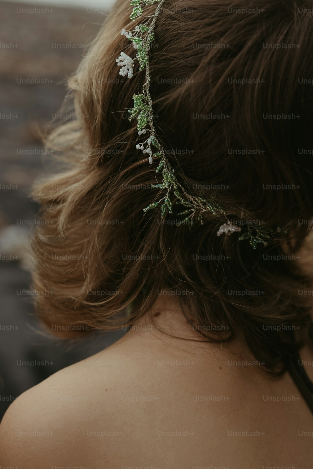 Un primo piano di una donna con un fiore tra i capelli