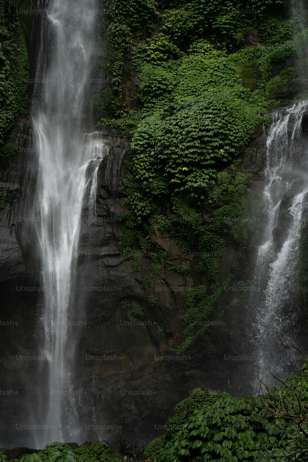 a couple of waterfalls in the middle of a forest