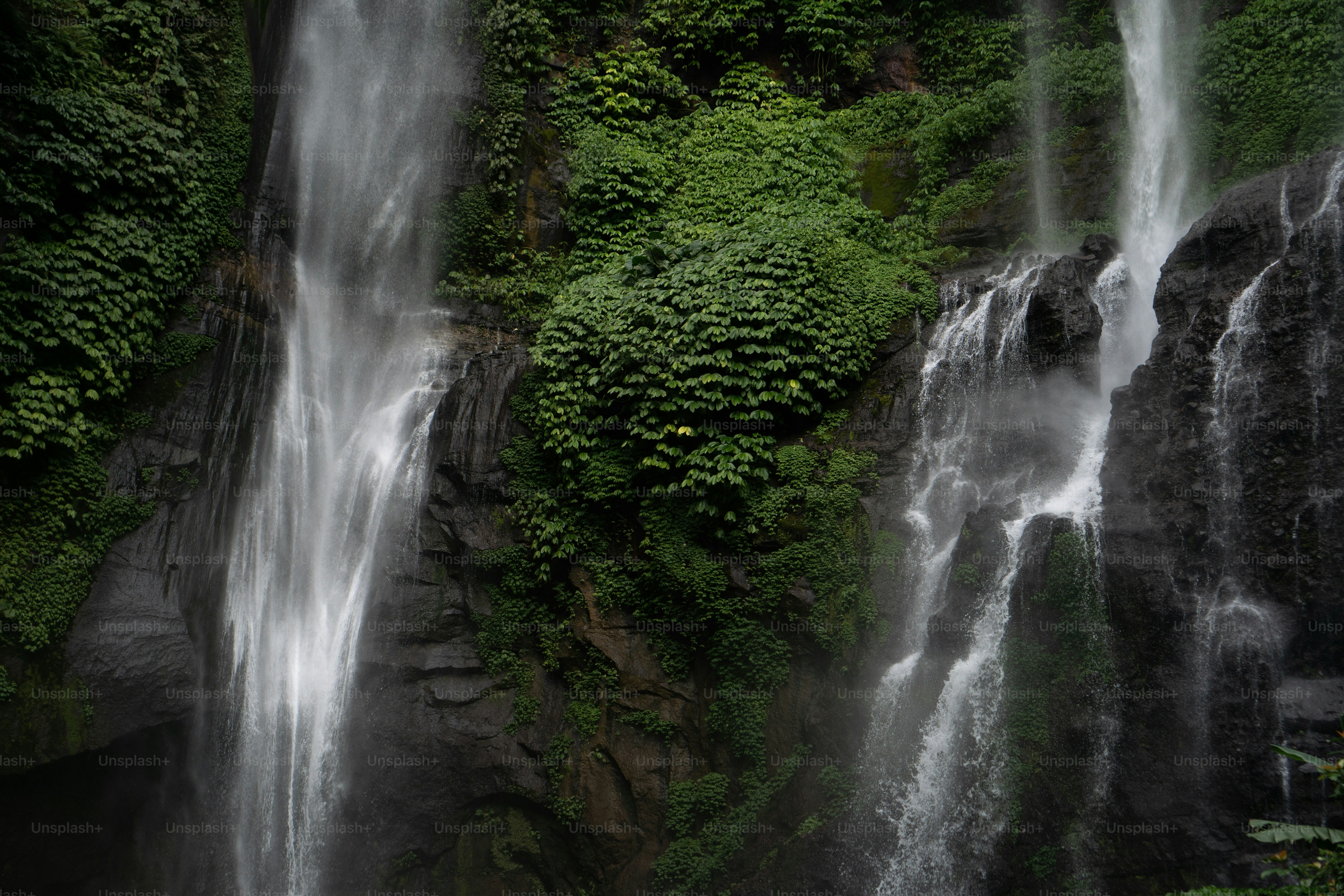 Un par de personas de pie frente a una cascada