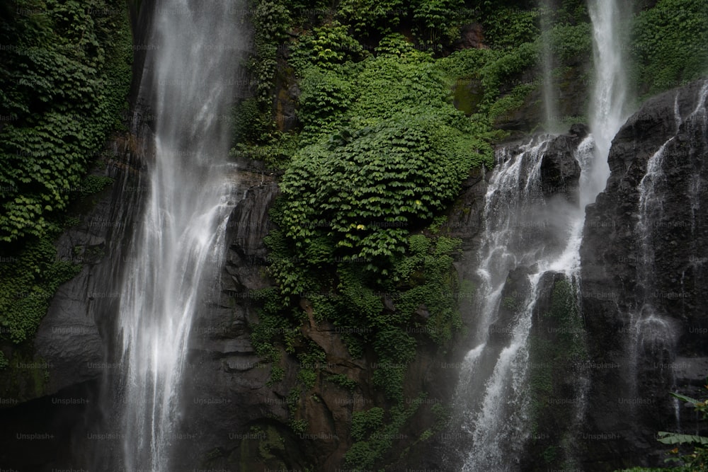 a couple of people standing in front of a waterfall