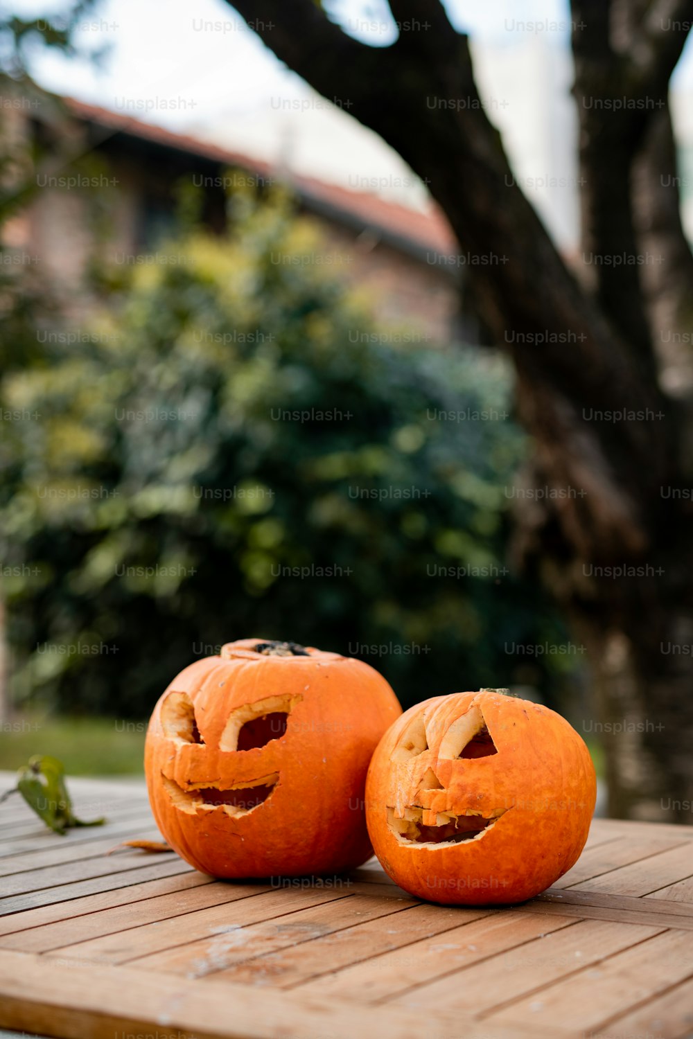 two jack o lantern pumpkins sitting on a wooden table