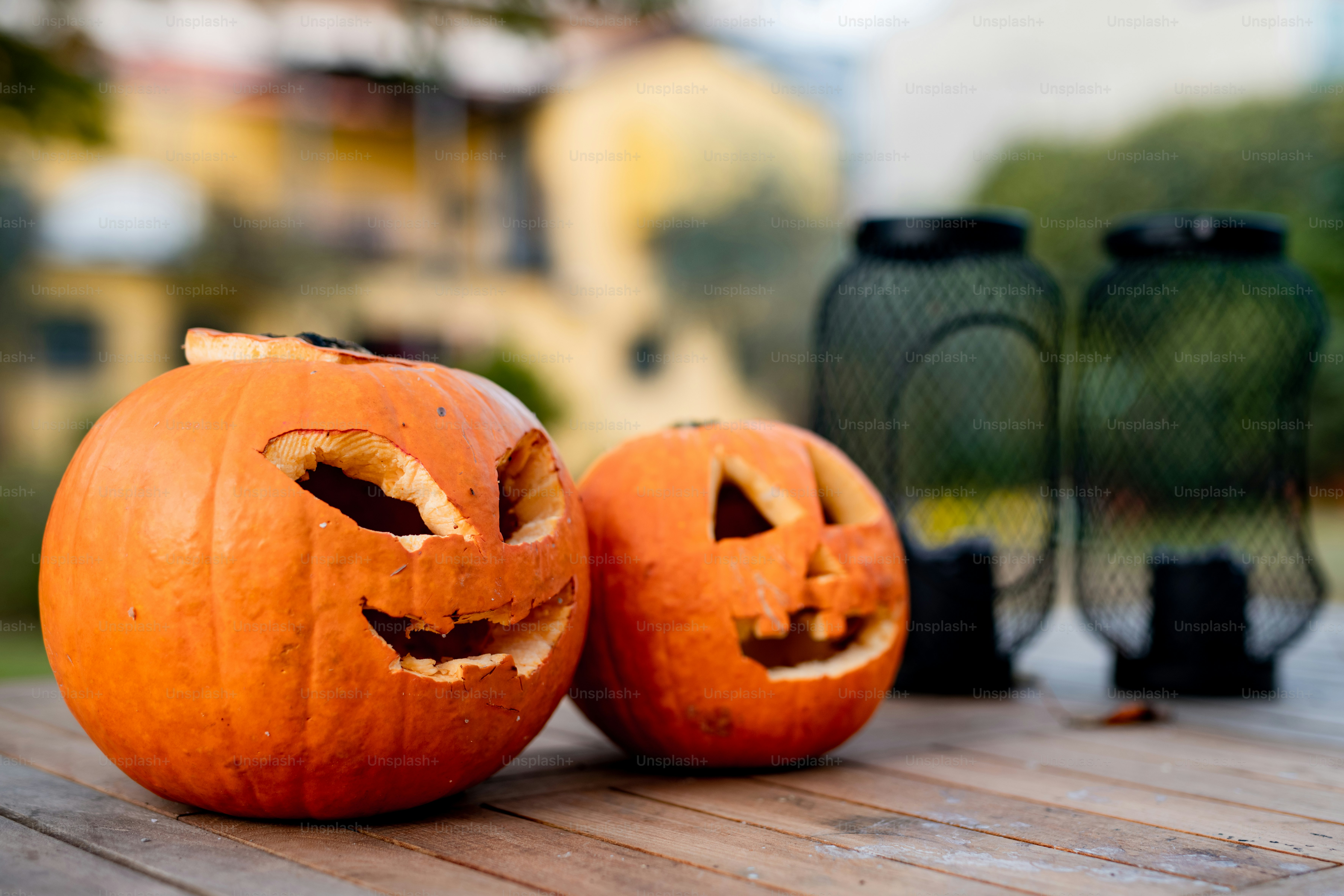 Deux citrouilles sculptées assises sur une table en bois