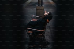 a woman laying on a bench in the dark