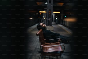 駅のベンチに横たわる男