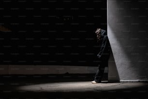 a person standing in the dark with their head down