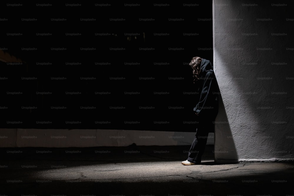 a person standing in the dark with their head down