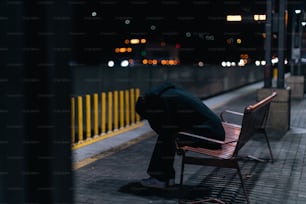 a person sitting on a bench in the dark