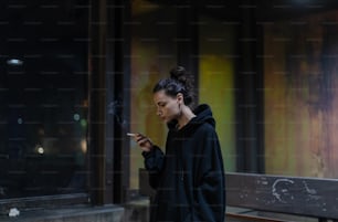a woman smoking a cigarette in front of a building