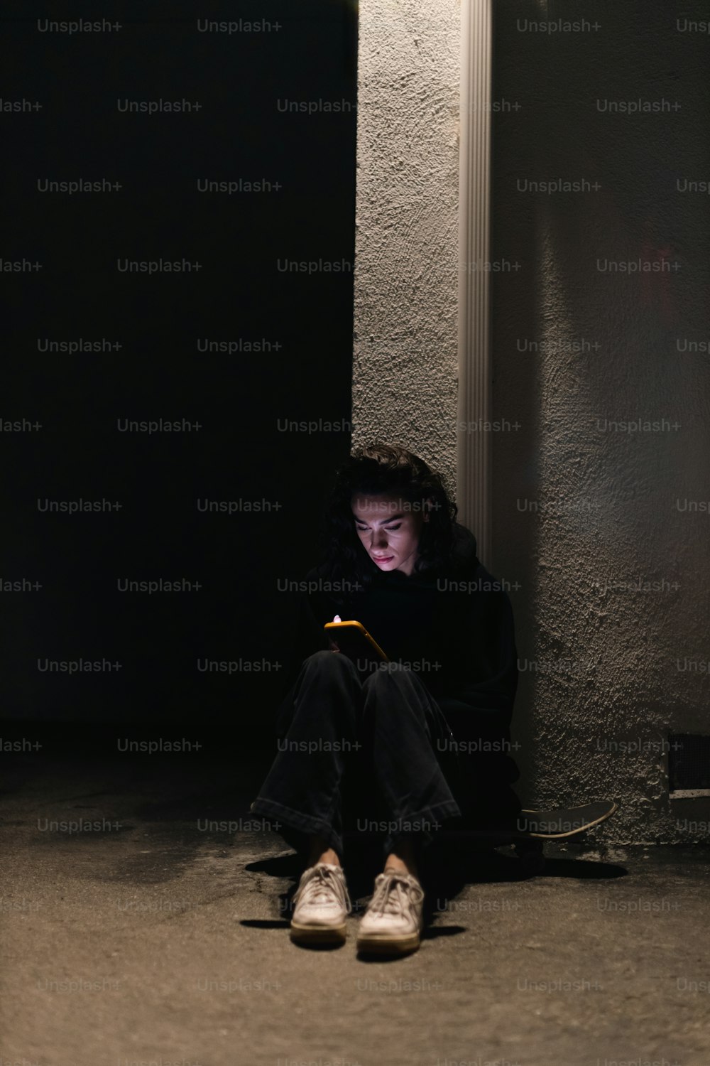 a person sitting on the ground with a cell phone