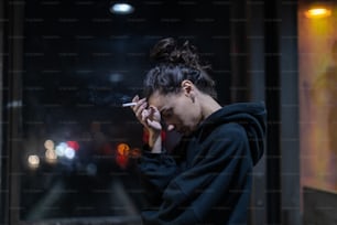 Una mujer fumando un cigarrillo en una habitación oscura