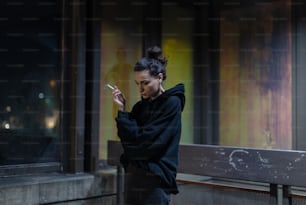 a woman standing in front of a window looking at her cell phone