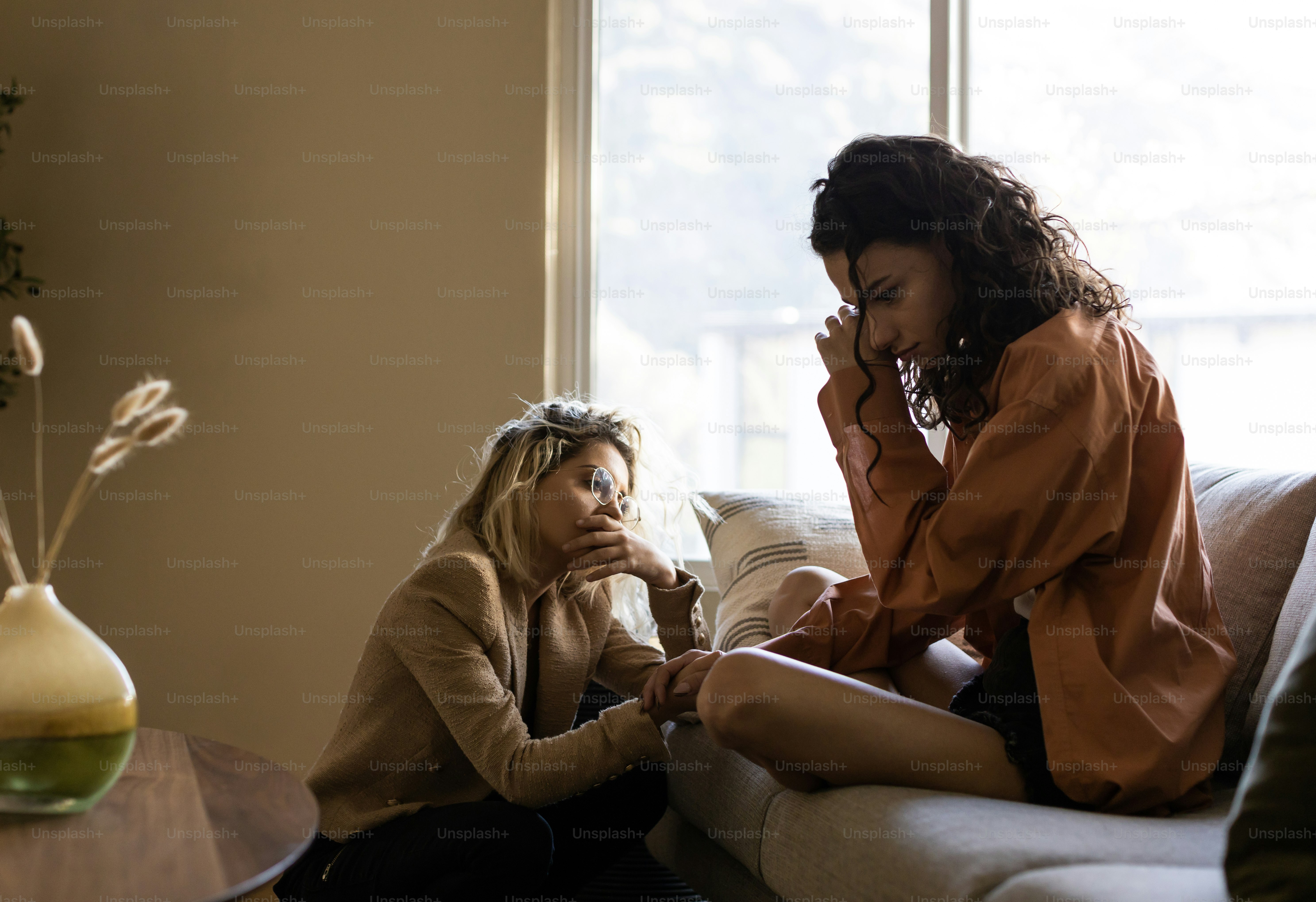 a woman sitting on a couch talking on a cell phone