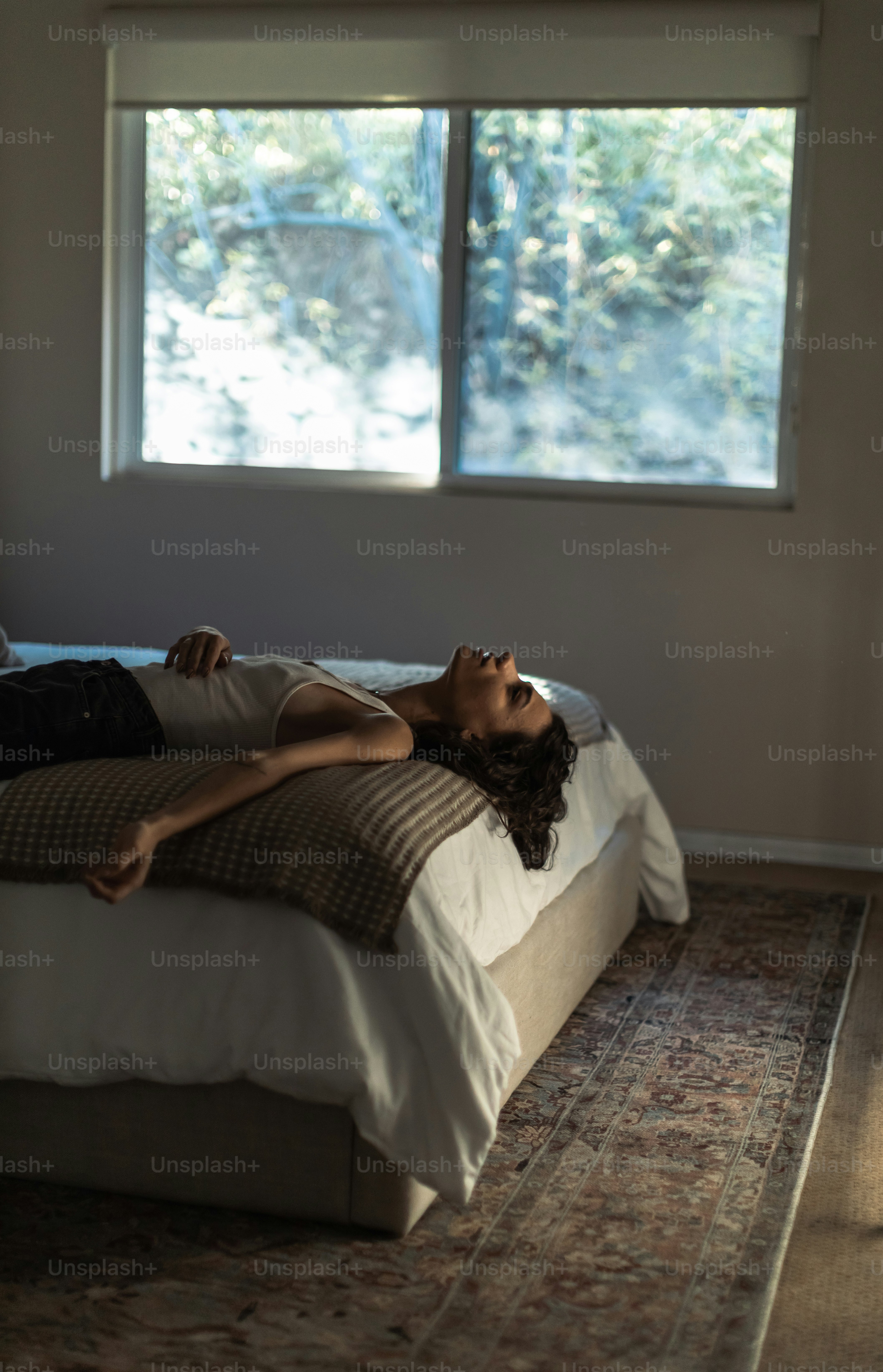 seorang wanita berbaring di tempat tidur di kamar tidur