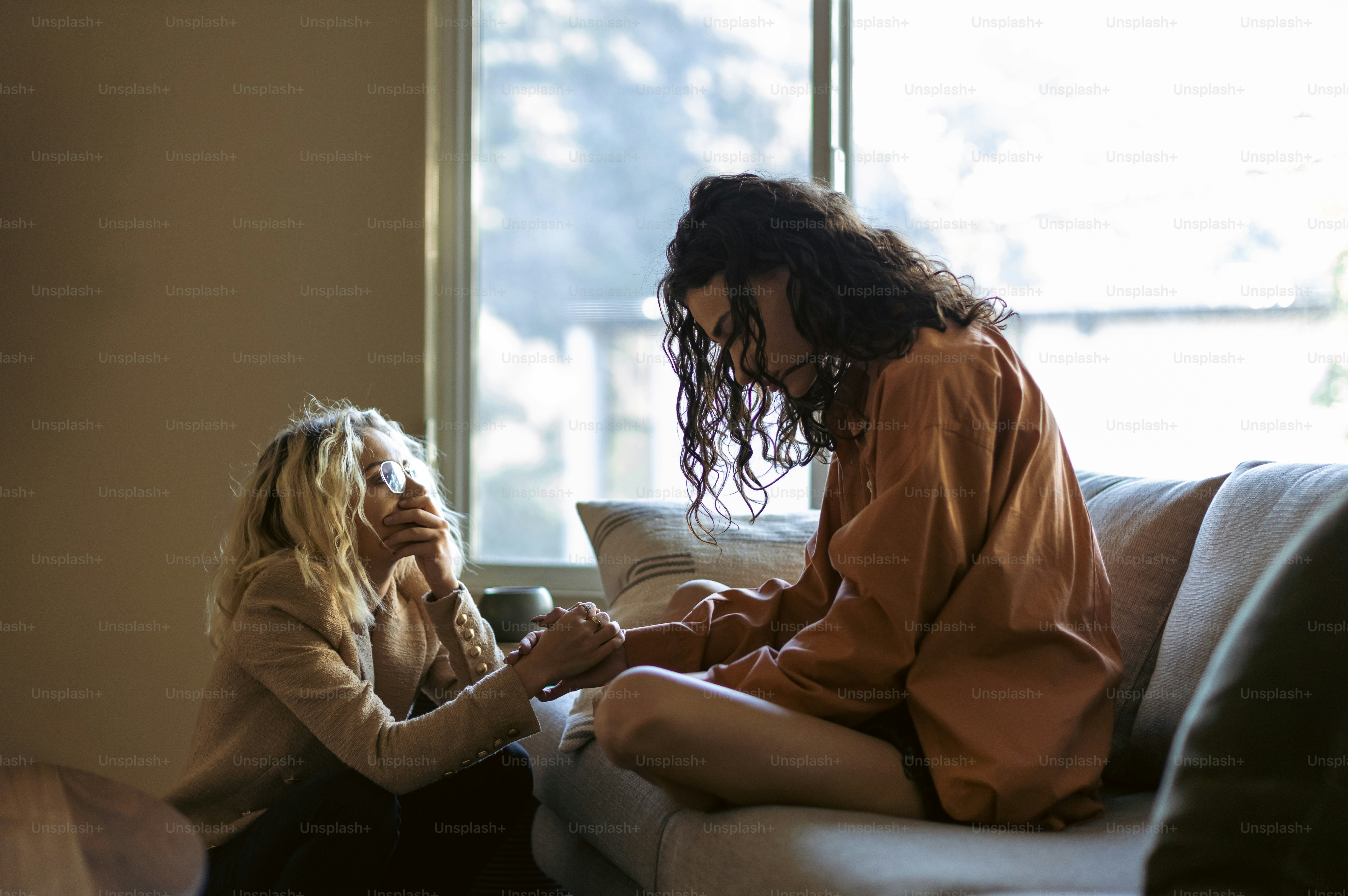 Dos mujeres sentadas en un sofá una al lado de la otra