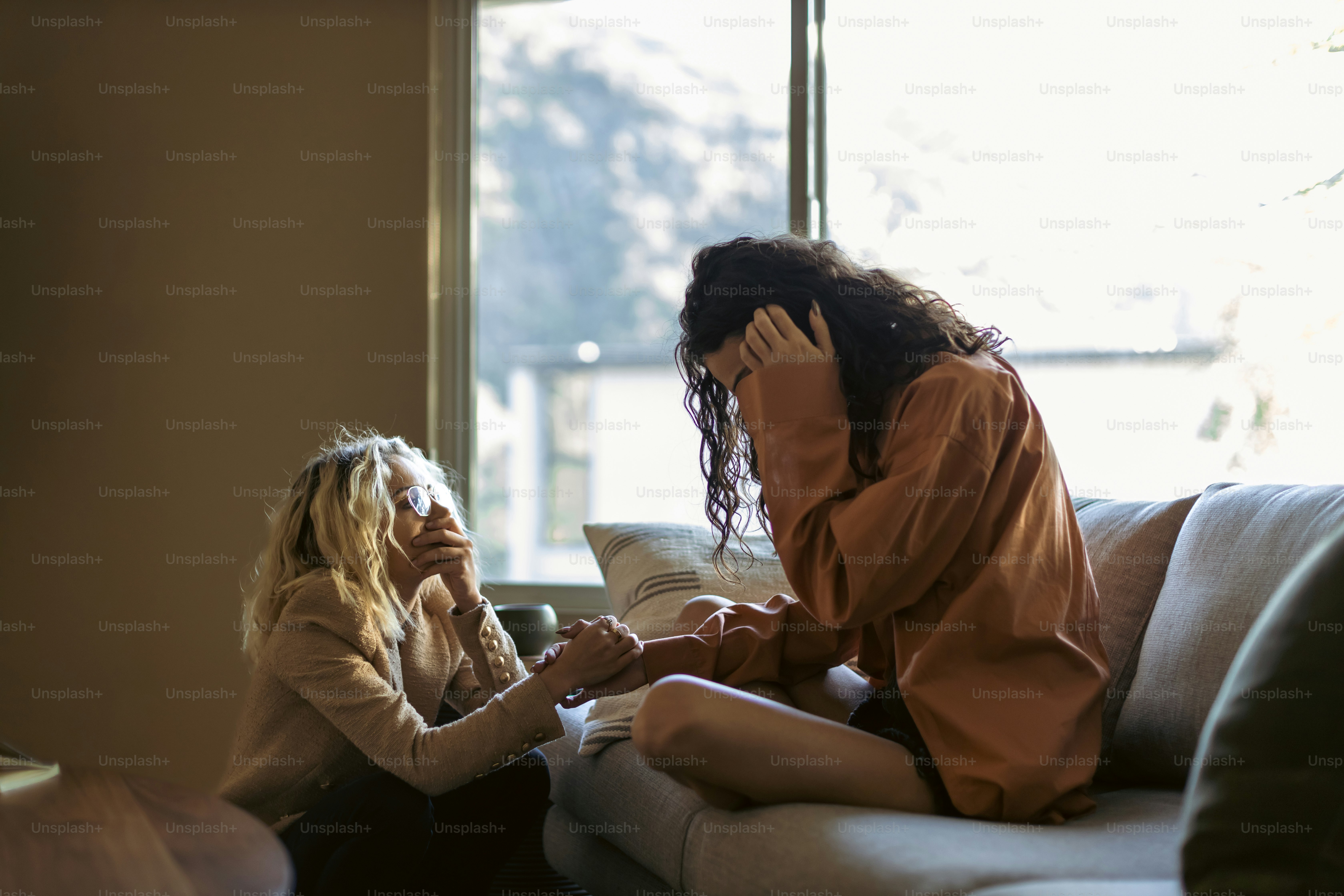 a woman sitting on a couch talking on a cell phone