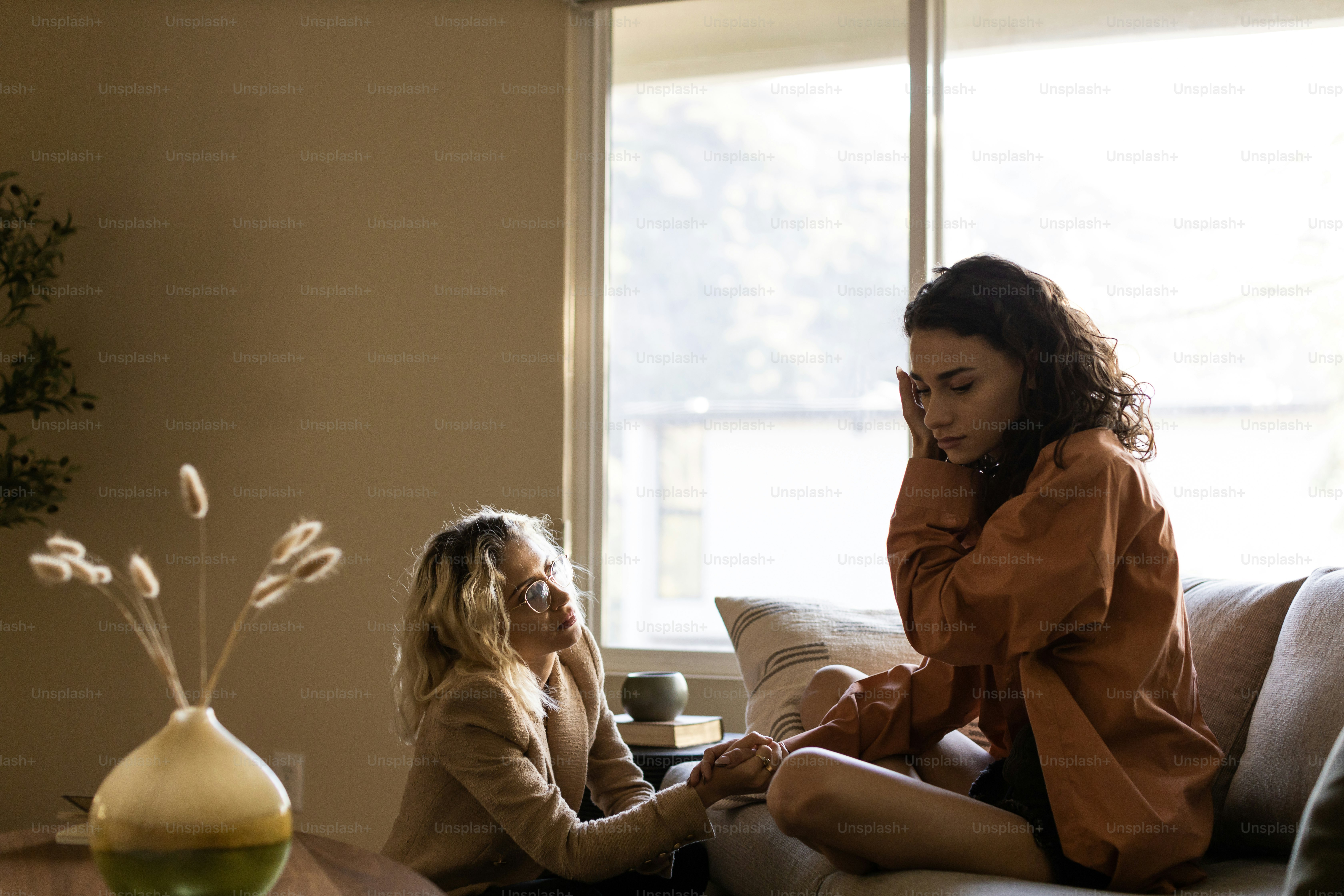 a woman sitting on a couch next to another woman