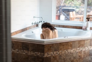 une femme assise dans une baignoire dans une salle de bain