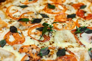 Eine Nahaufnahme einer Pizza mit Tomaten und Basilikum
