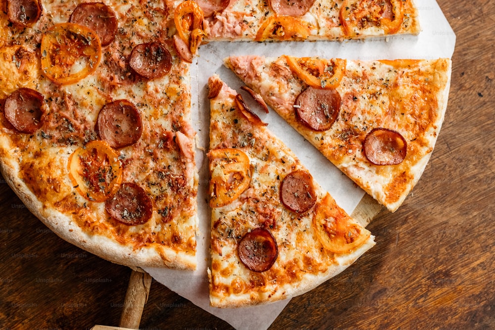 a pepperoni pizza cut into slices on a wooden table