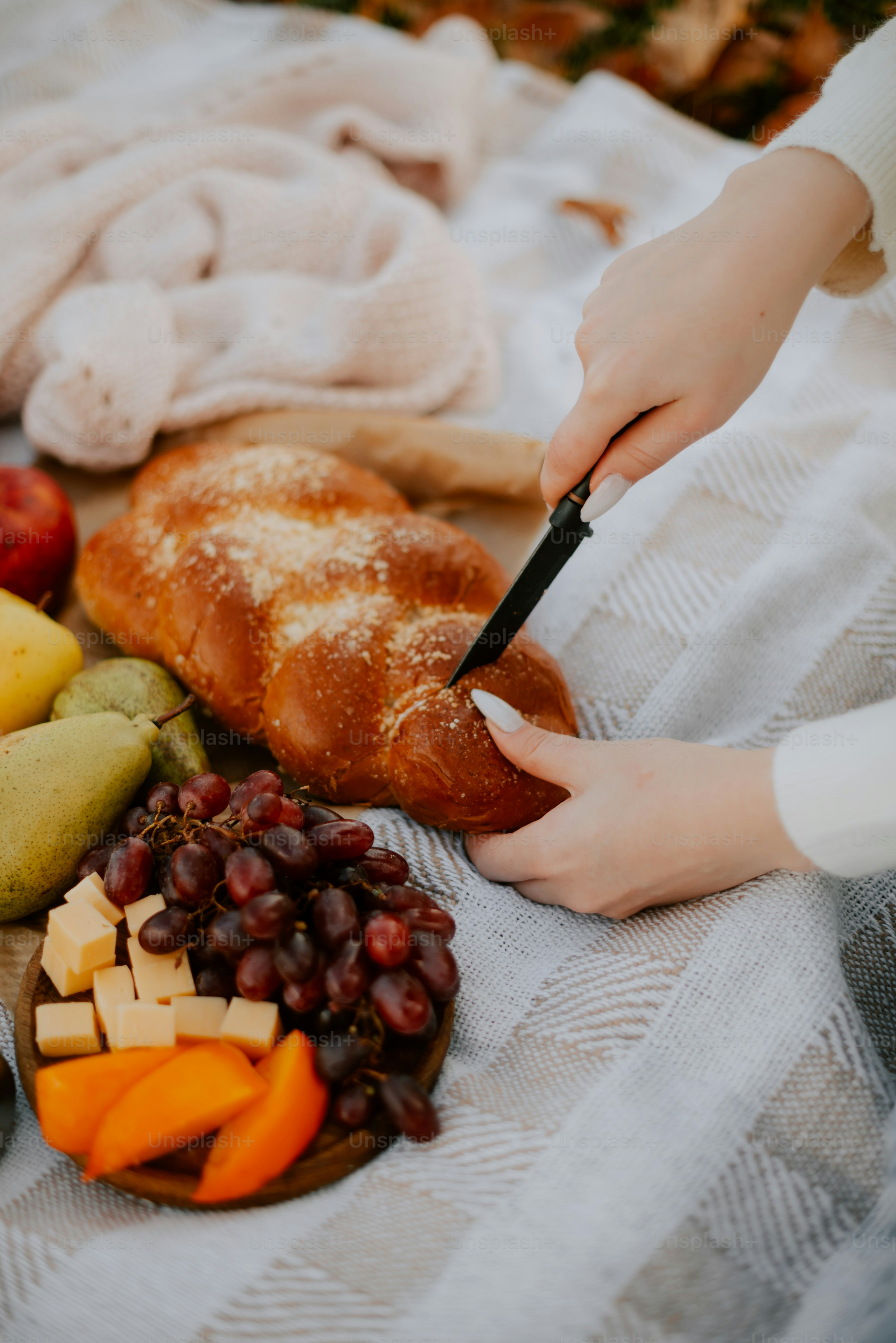 a person cutting a piece of bread on top of a table