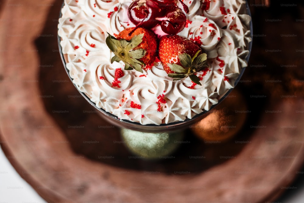 ein Kuchen mit weißem Zuckerguss und Erdbeeren oben drauf