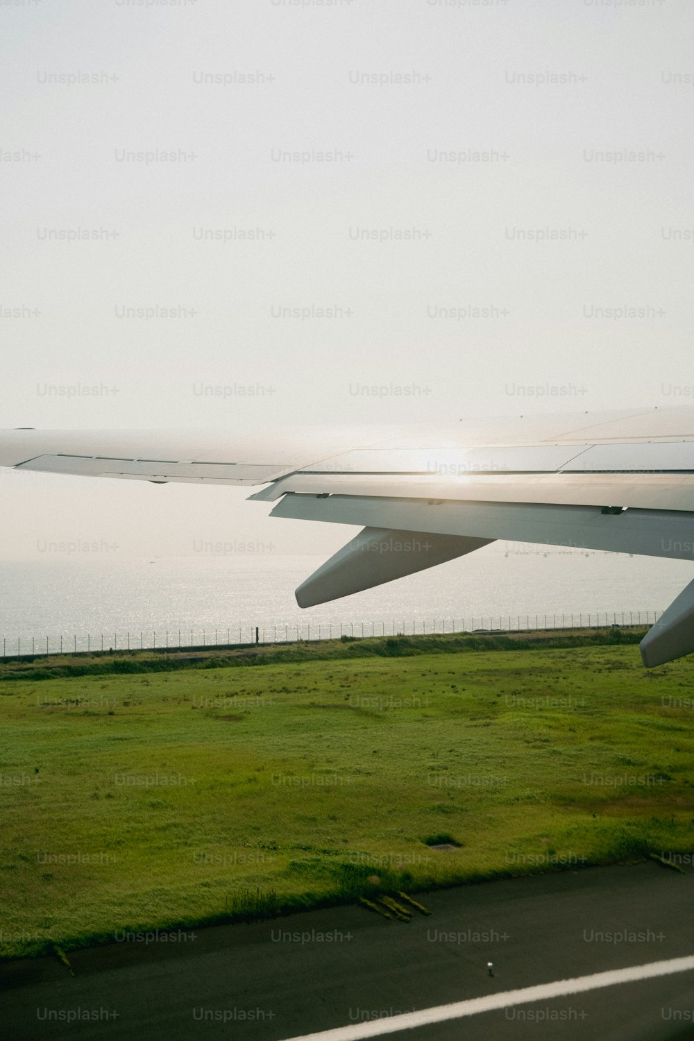 the wing of an airplane flying over a field