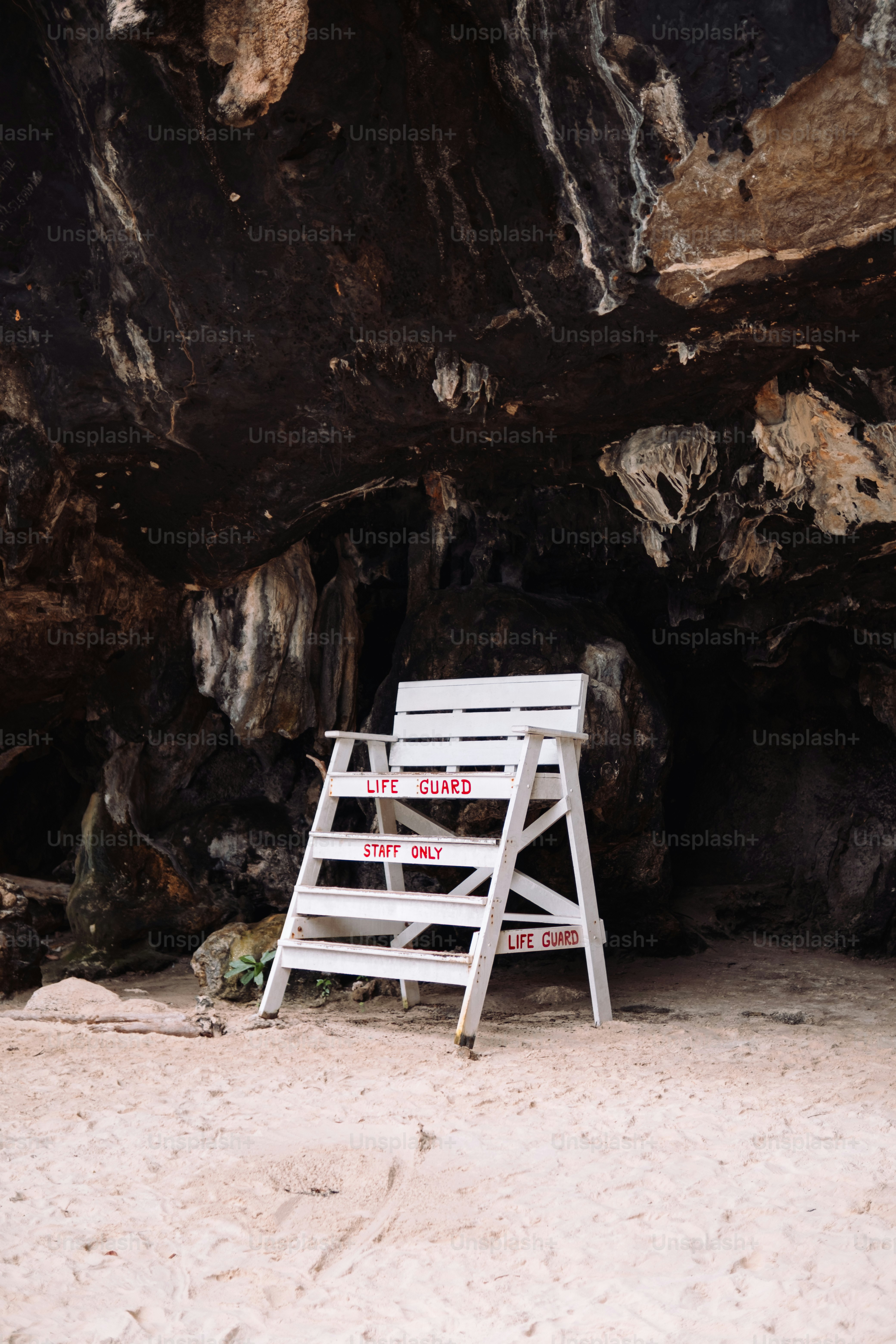 a white chair sitting on top of a sandy beach