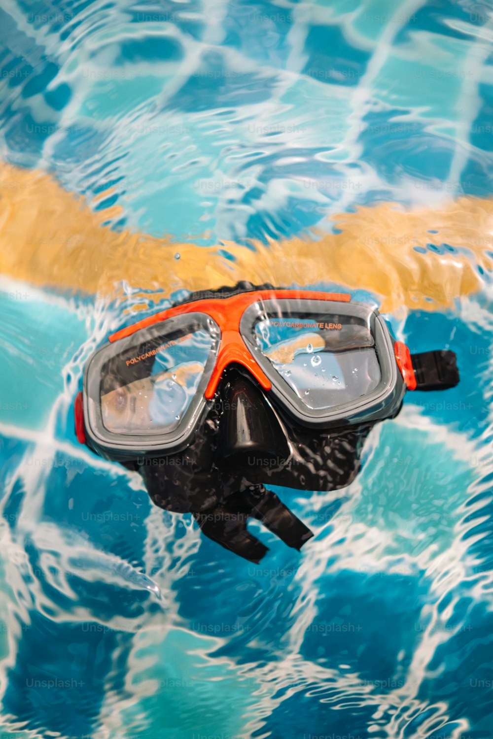 a person swimming in a pool with a mask and goggles