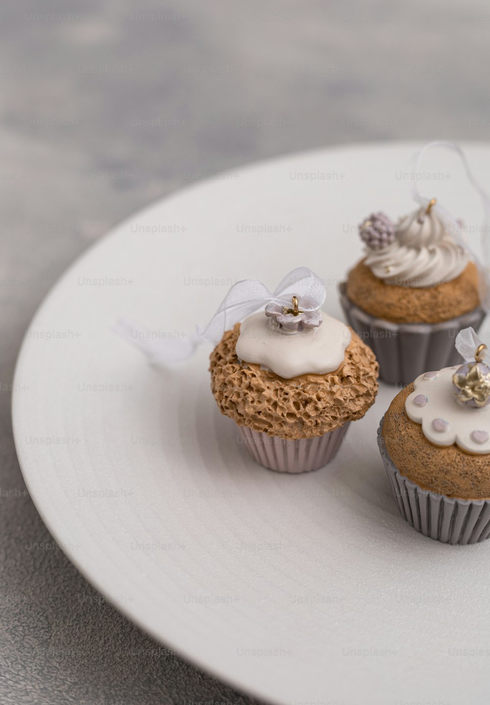 three cupcakes on a white plate on a table