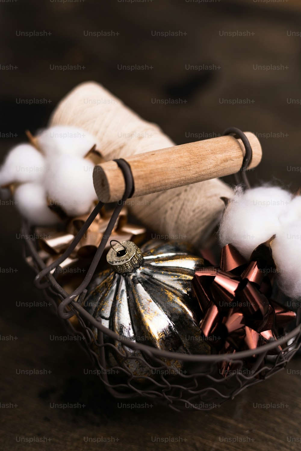 a basket filled with cotton and a wooden spool