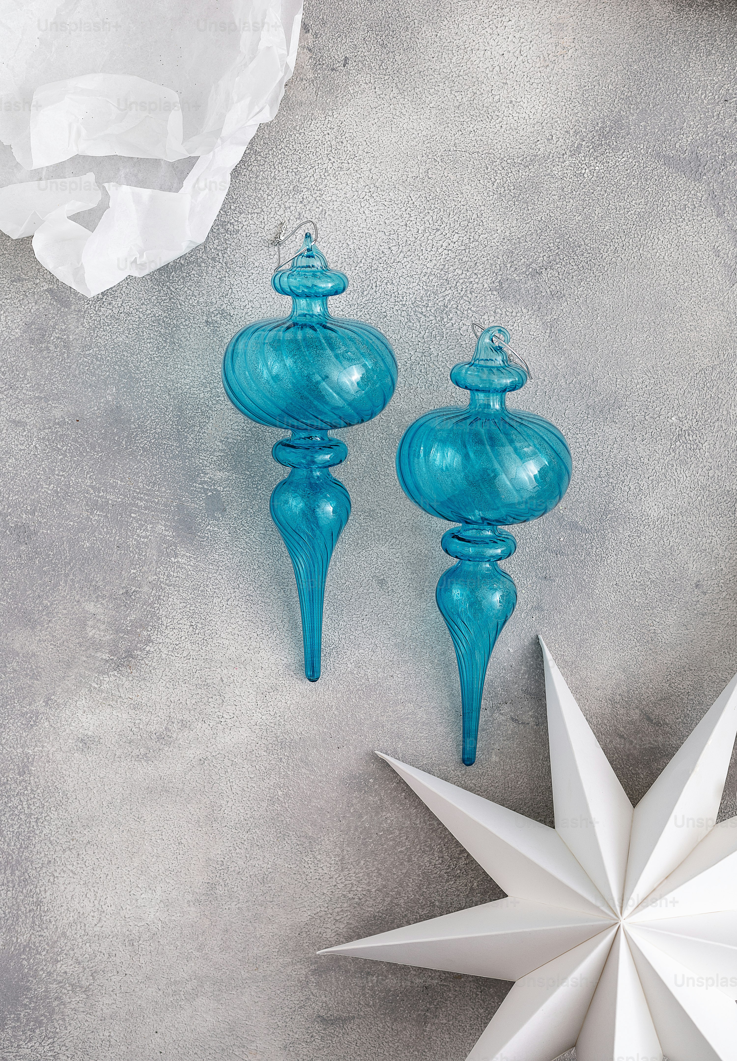two blue glass ornaments sitting on top of a table