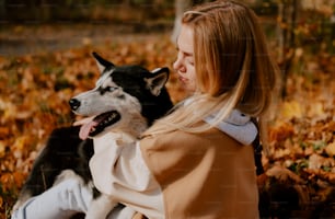 a woman sitting on the ground with her dog