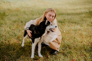 a woman kneeling down with a dog in her lap