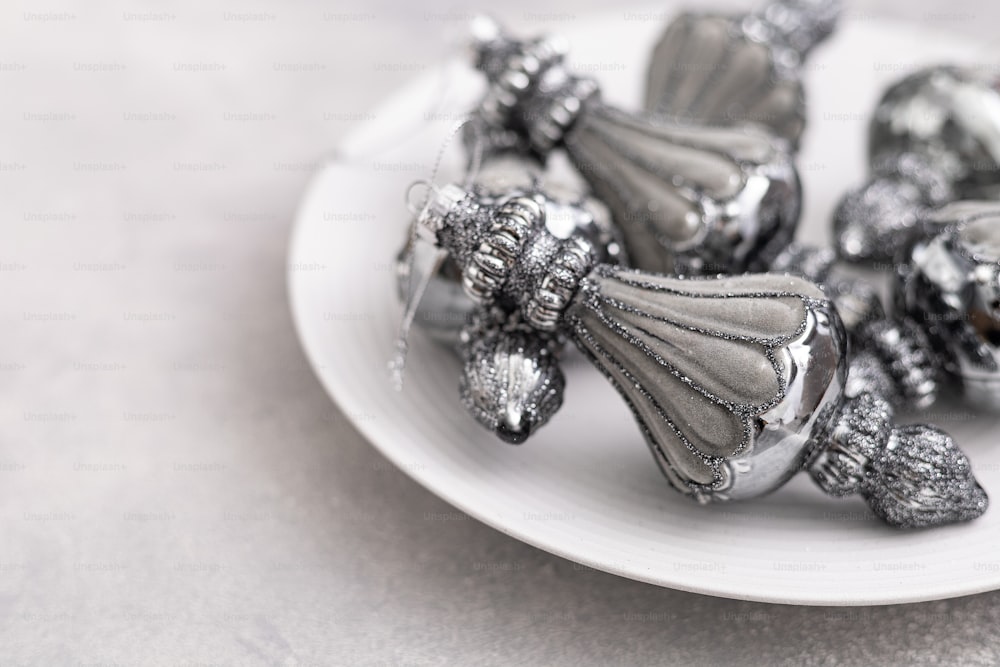 um prato branco coberto com doces de prata em cima de uma mesa