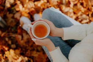 Une femme tenant une tasse de thé dans ses mains