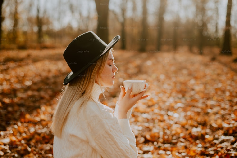 uma mulher em um chapéu segurando uma xícara de café