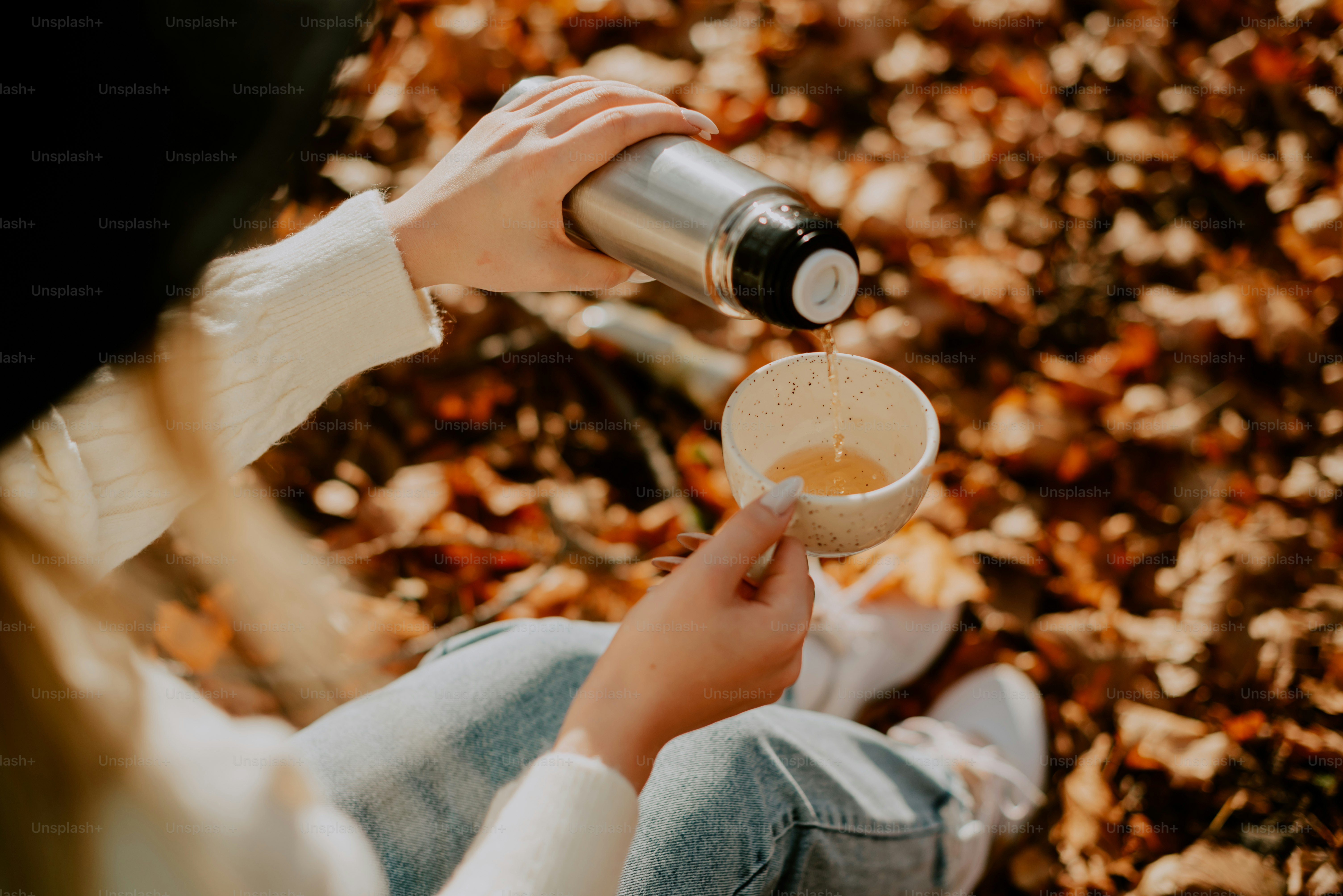 uma mulher está sentada no chão com uma xícara de café