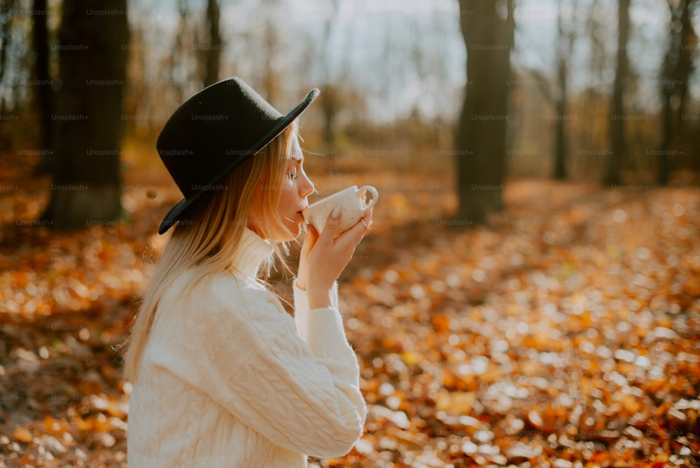 Una donna con un cappello sta bevendo da una tazza