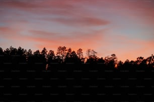 the sky is pink and orange as the sun sets