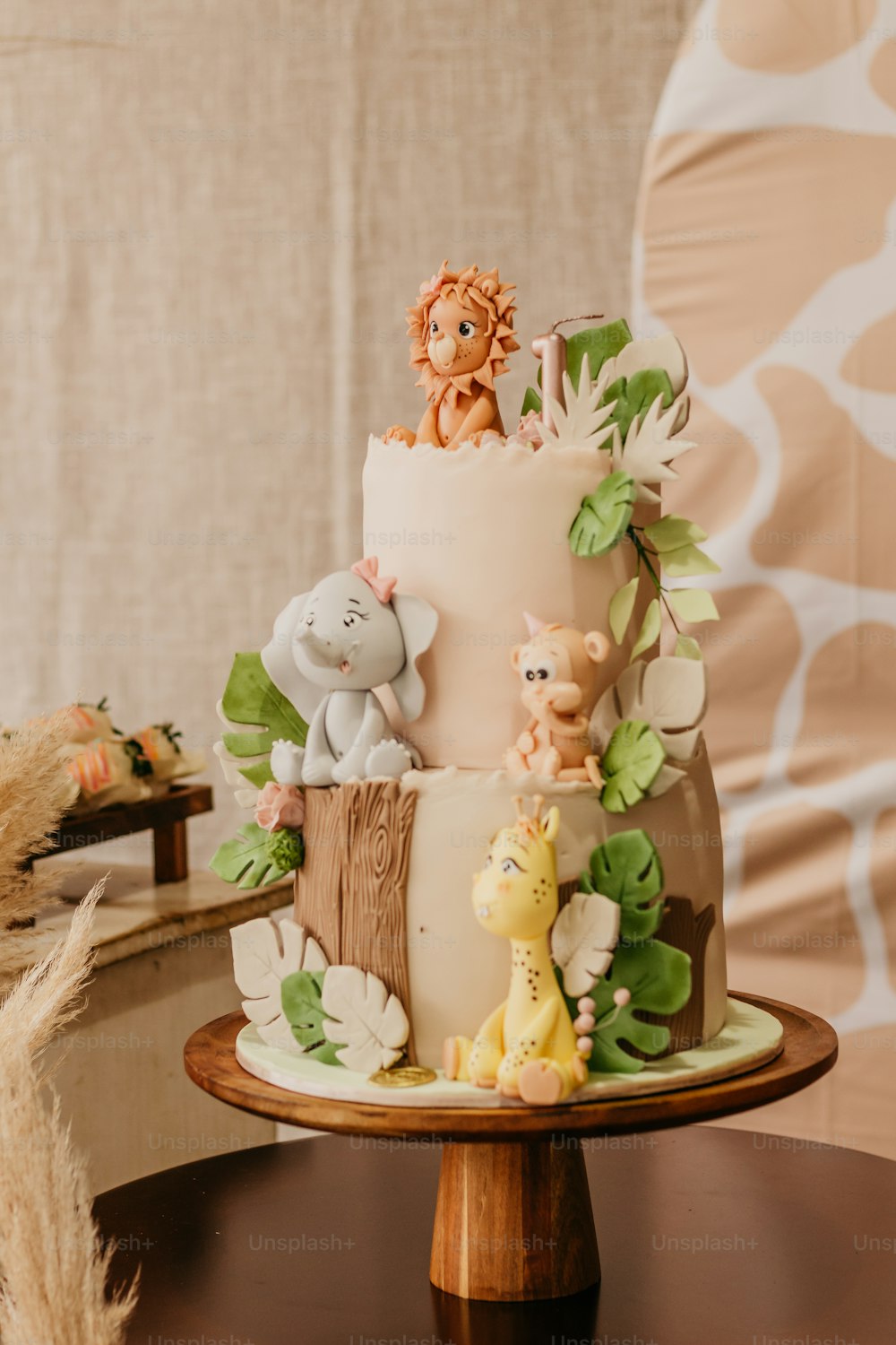 a three tiered cake decorated with jungle animals