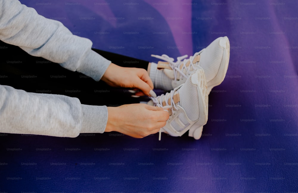 a person tying a pair of tennis shoes