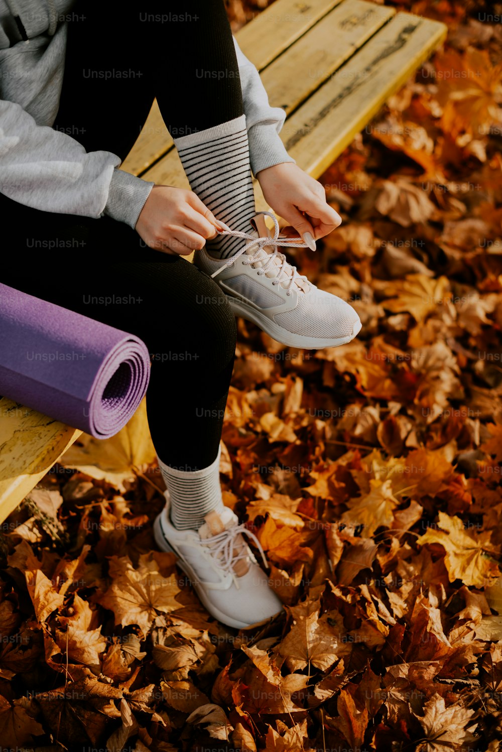 a person sitting on a bench with a yoga mat