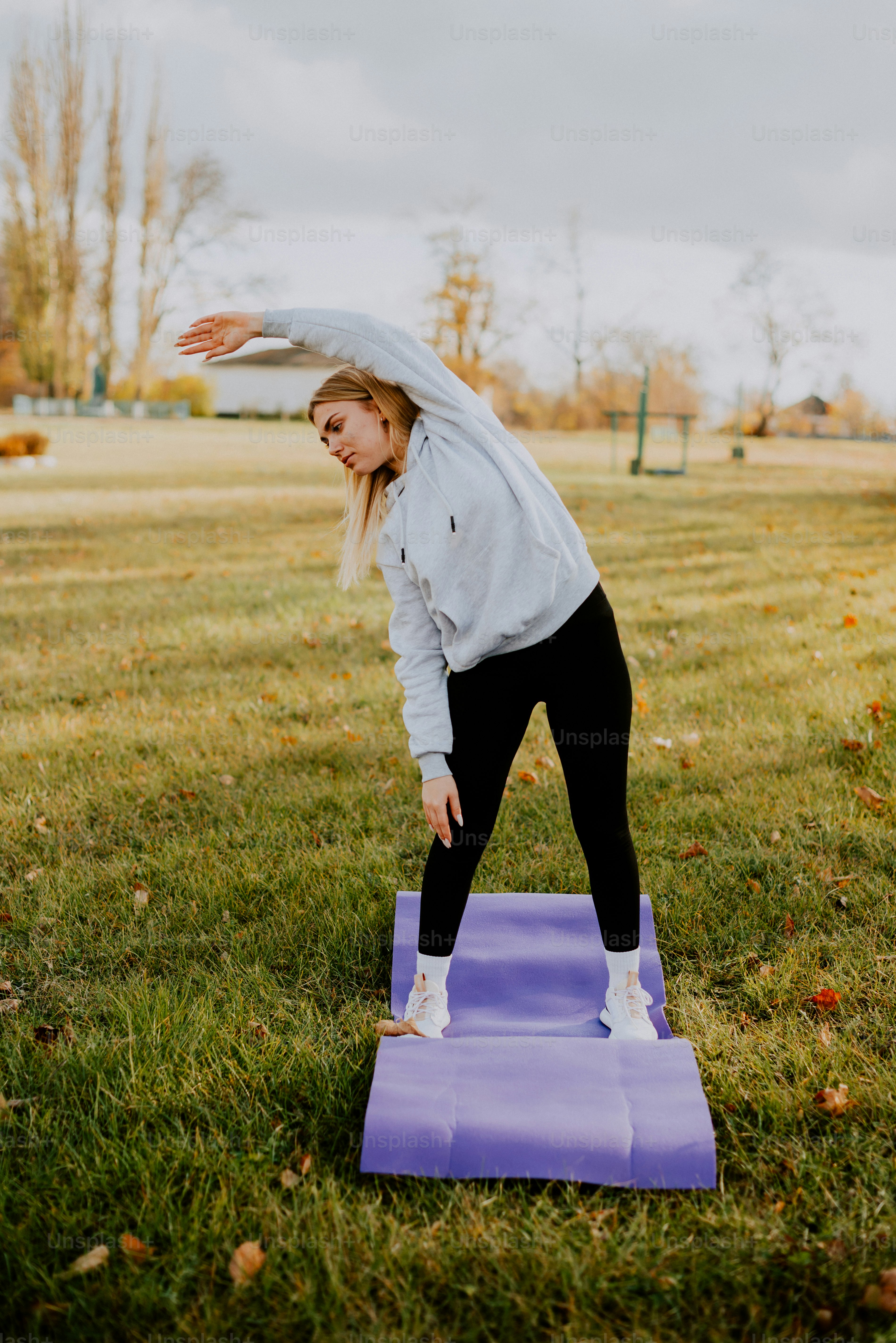 Une femme faisant une pose de yoga sur un tapis violet