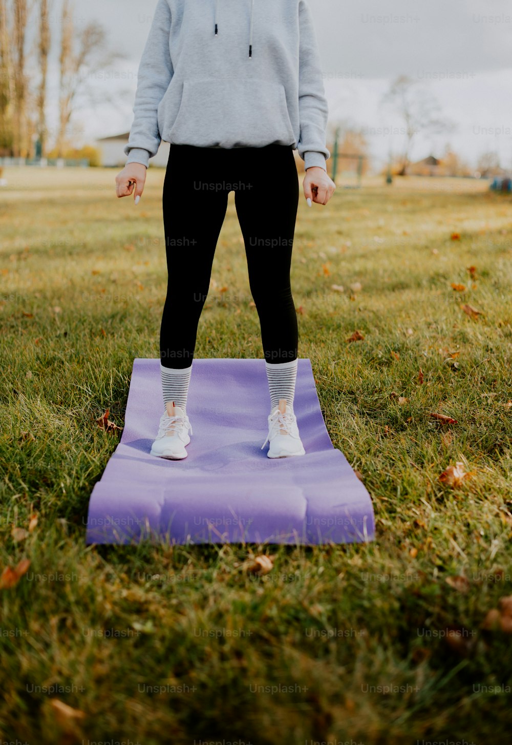 a person standing on a purple mat in a field