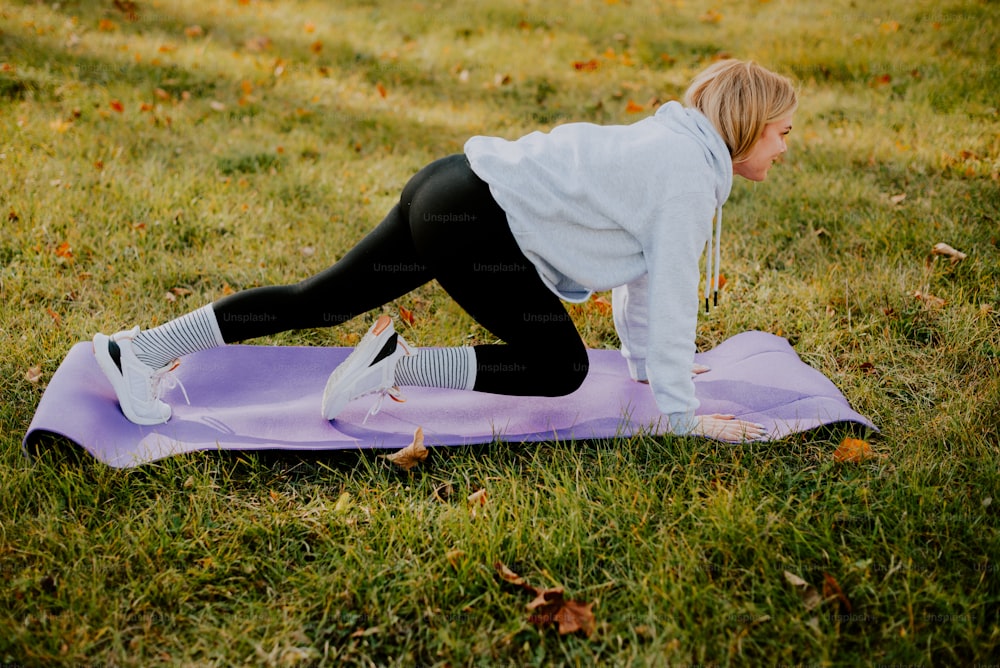 uma mulher fazendo uma prancha em um tapete de ioga