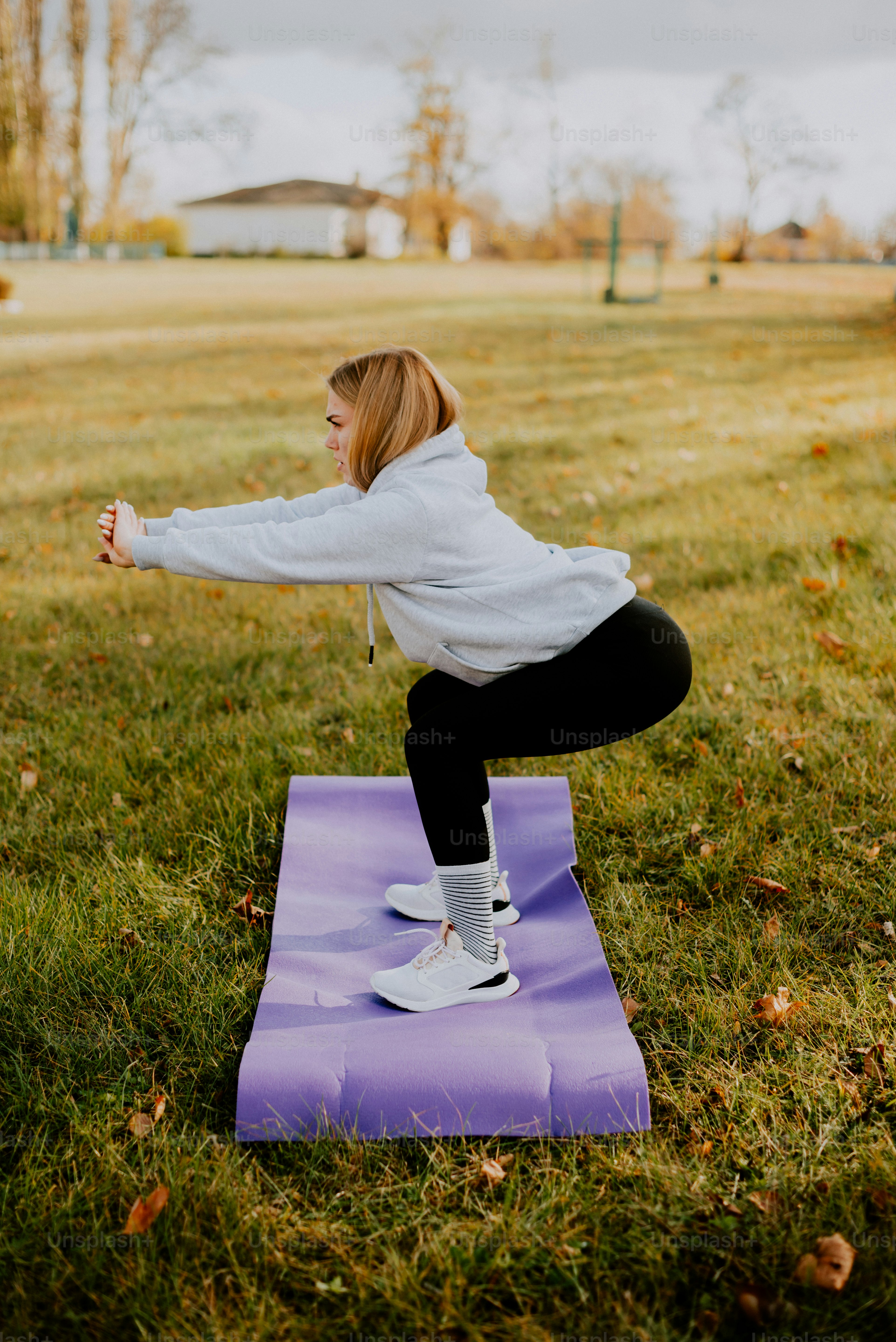 Une femme faisant une pose de yoga sur un tapis violet