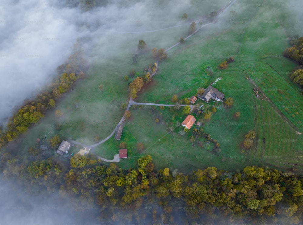 an aerial view of a farm surrounded by clouds