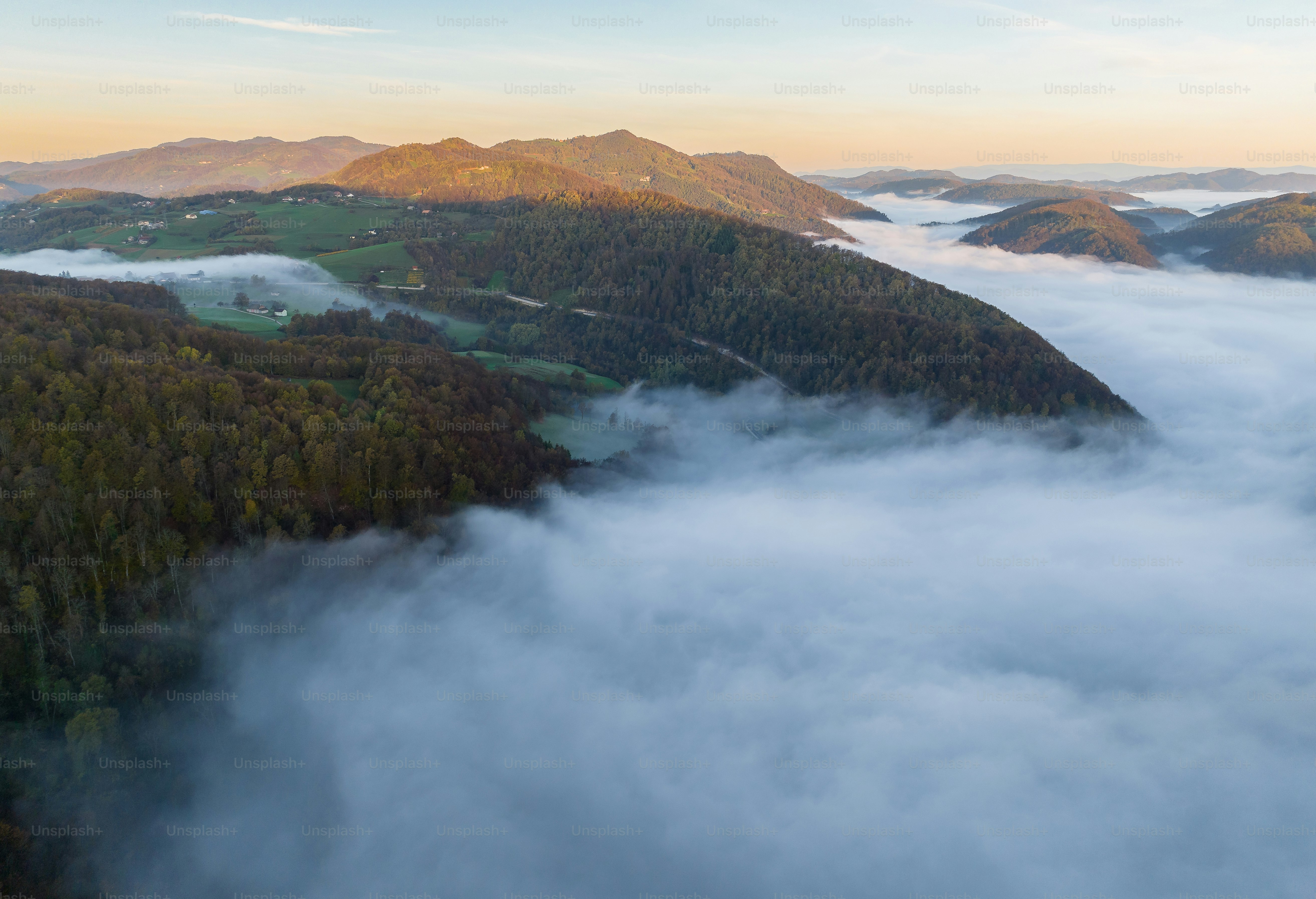 An aerial view of a foggy valley in the mountains photo – Sunset Image ...
