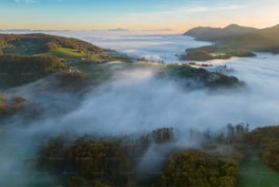 an aerial view of a foggy valley in the mountains