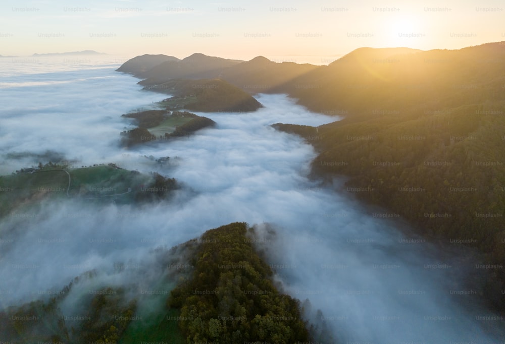 an aerial view of a mountain range covered in clouds